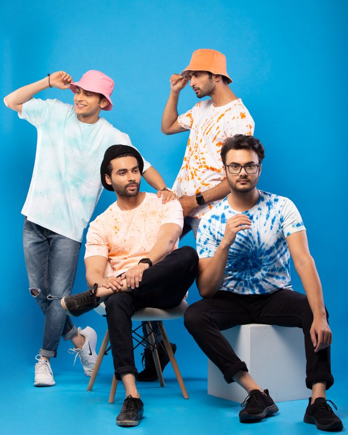 services-02 A stylish group of men posing in colorful tie-dye T-shirts in a studio setting.